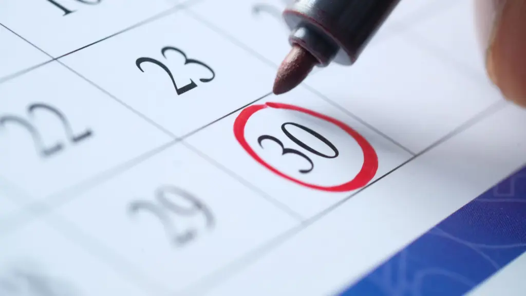 A person circling the 30th on a calendar.