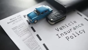 A blue toy car and a car key on top of a car insurance policy packet.