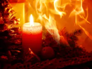 A Christmas candle surrounded by a roaring house fire. 